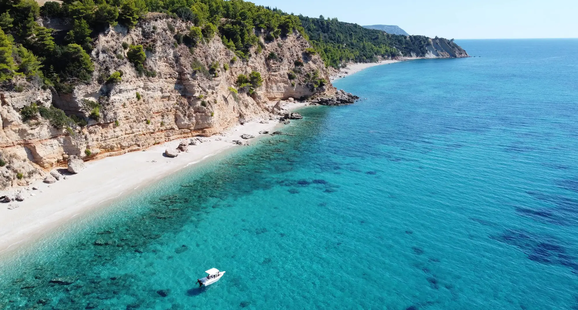 A rental boat anchored near a secluded beach in South Kefalonia, enjoying a private day at sea